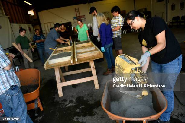 Instructor Moses Alvarez, fourth from left,, teaches the finer points of finishing concrete in forms to students taking part in the Construction...