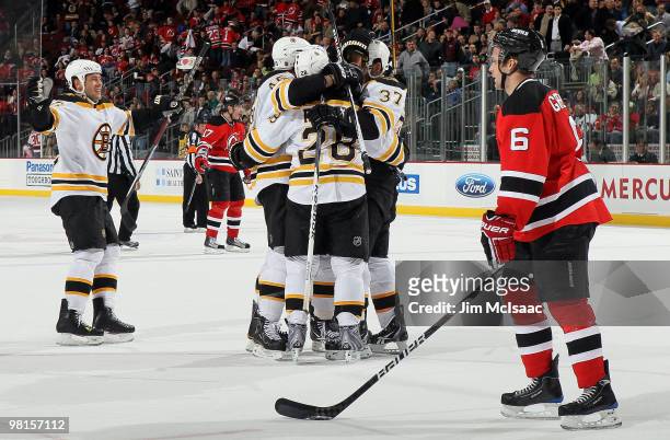Patrice Bergeron of the Boston Bruins celebrates his overtime goal with his teammates as Andy Greene of the New Jersey Devils looks on at the...