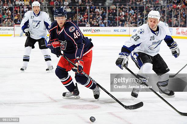 Tomas Kana of the Columbus Blue Jackets battles for control of a loose puck with Zenon Konopka of the Tampa Bay Lightning during the first period on...