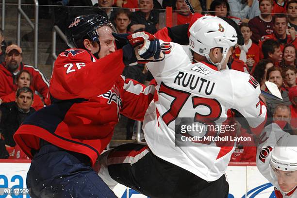 Shaone Morrisonn of the Washington Capitals puts a hit on Jarkko Ruutu of the Ottawa Senators during an NHL hockey game against the Ottawa Senators...