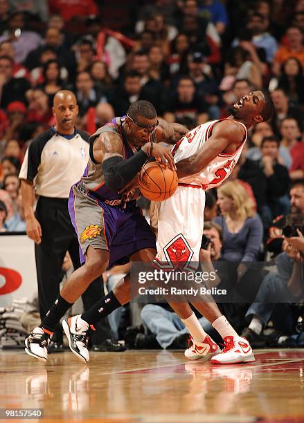 Amar'e Stoudemire of the Phoenix Suns attempts to drive the ball around Hakim Warrik of the Chicago Bulls during a NBA game on March 30, 2010 at the...