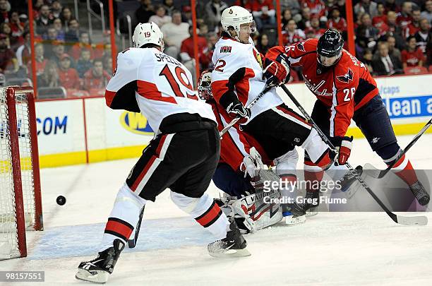 Jason Spezza of the Ottawa Senators scores a goal in the first period as Mike Fisher is pushed into Jose Theodore by Shaone Morrisonn of the...