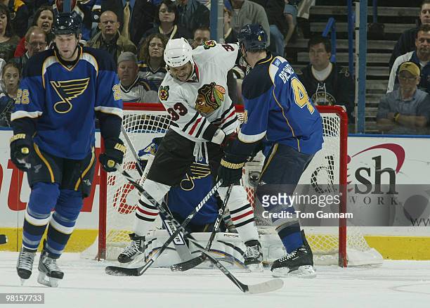 Crombeen and Eric Brewer of the St. Louis Blues defend against Dustin Byfuglien of the Chicago Blackhawks on March 30, 2010 at Scottrade Center in...