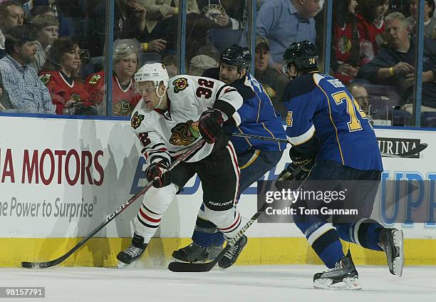 Kris Versteeg of the Chicago Blackhawks handles the puck as Barret Jackman and T.J. Oshie defend on March 30, 2010 at Scottrade Center in St. Louis,...