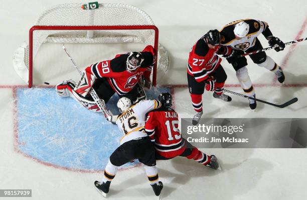 Marco Sturm of the Boston Bruins is stopped By Martin Brodeur and Travis Zajac of the New Jersey Devils as Mike Mottau defends against Boston's Zdeno...