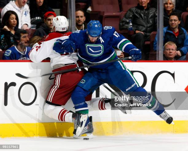 Ryan Kesler of the Vancouver Canucks checks Derek Morris of the Phoenix Coyotes into the boards during their game at General Motors Place on March...