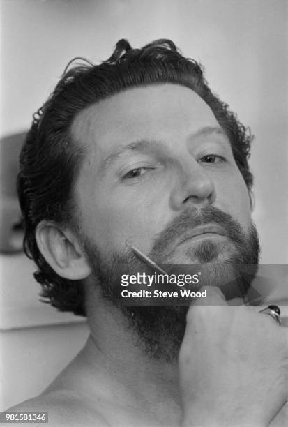 American musician and singer Jerry Lee Lewis pictured combing his beard backstage at the Palladium in London on 24th April 1972.