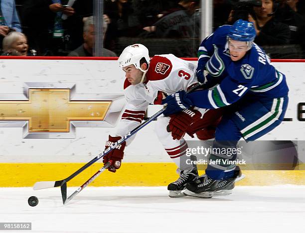 Mason Raymond of the Vancouver Canucks races for the loose puck against Keith Yandle of the Phoenix Coyotes during their game at General Motors Place...