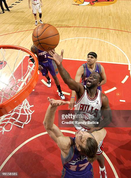Ronald Murray of the Chicago Bulls lays the ball up and over Louis Amundson of the Phoenix Suns, as Jared Dudley of the Suns watches from behind...