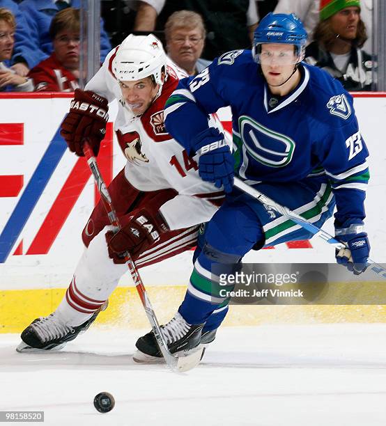 Alexander Edler of the Vancouver Canucks and Taylor Pyatt of the Phoenix Coyotes battle for the puck during their game at General Motors Place on...