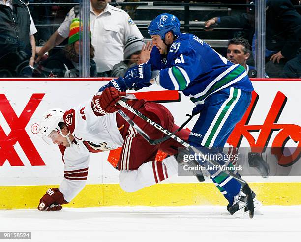 Andrew Alberts of the Vancouver Canucks checks Shane Doan of the Phoenix Coyotes to the ice during their game at General Motors Place on March 30,...