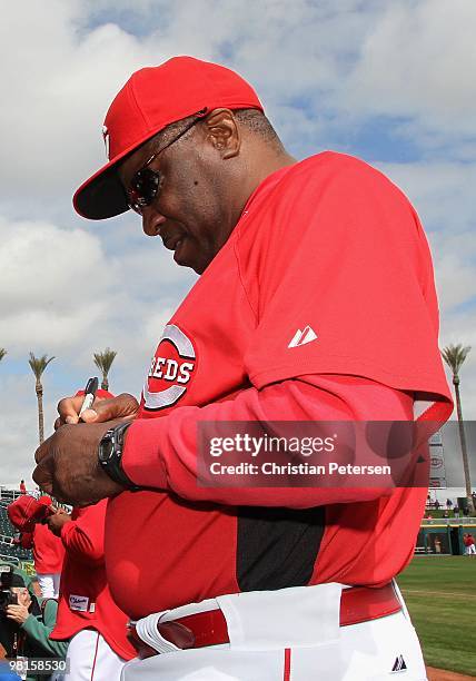 Manager Dusty Baker of the Cincinnati Reds signs autographs before the MLB spring training game against the Kansas City Royals at Goodyear Ballpark...