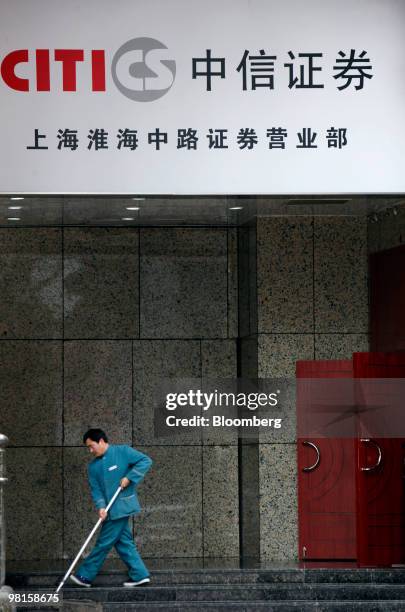 Cleaner sweeps thhe staircase in front of a Citic Securities Co. Branch in Shanghai, China, March 31, 2010. Citic Securities Co., China's biggest...