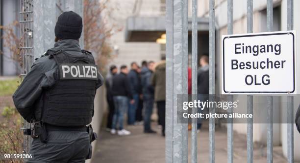 March 2018, Germany, Stuttgart: Visitors standing at the entrance to the court before the start of the trial against alleged leader of the Turkish...