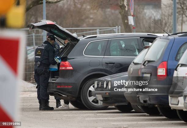 March 2018, Germany, Stuttgart: Police officers inspecting a car at the court before the start of the trial against alleged leader of the Turkish...