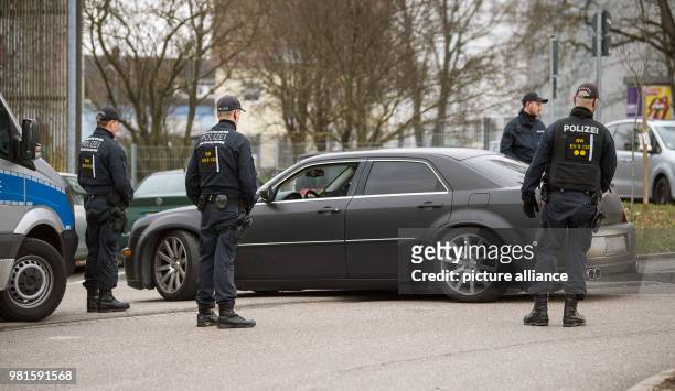 March 2018, Germany, Stuttgart: Police officers inspecting a car at the court before the start of the trial against alleged leader of the Turkish...