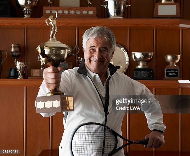 proud senior man holding squash trophy and racquet - trophy shelf imagens e fotografias de stock