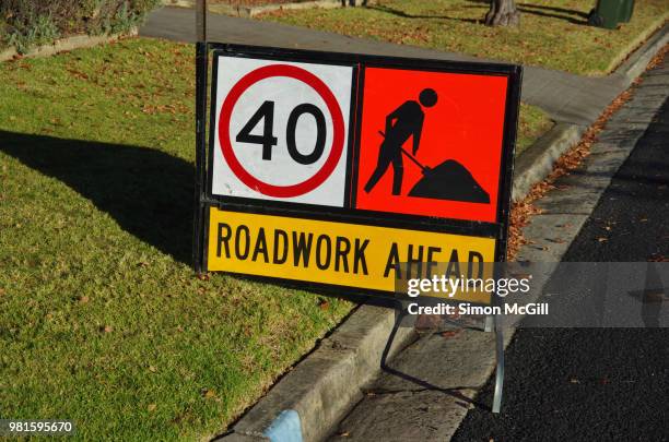 'road work ahead', manual worker ahead and 40 kilometer per hour speed limit signs on a suburban road - señal-de-obras-en-la-vía fotografías e imágenes de stock