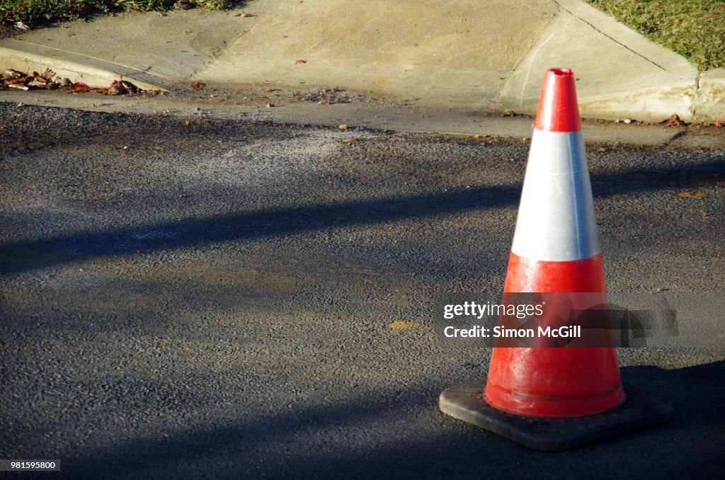 Traffic cone near road construction on a suburban street