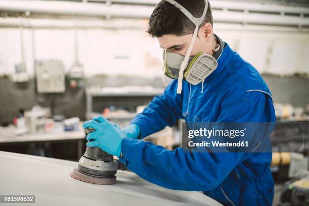 man polishing the hood of a car in a workshop - grinder stock-fotos und bilder
