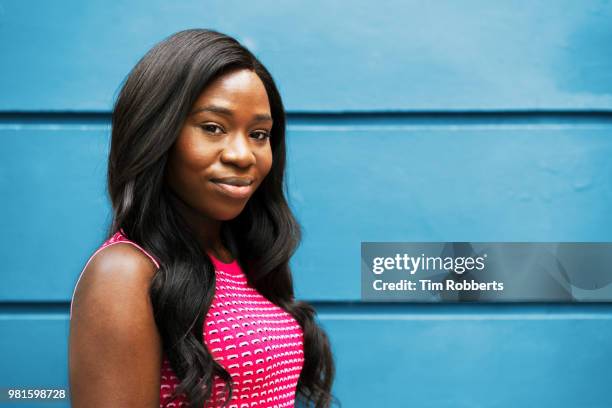 portrait of woman infront of wall - black woman long hair stock pictures, royalty-free photos & images