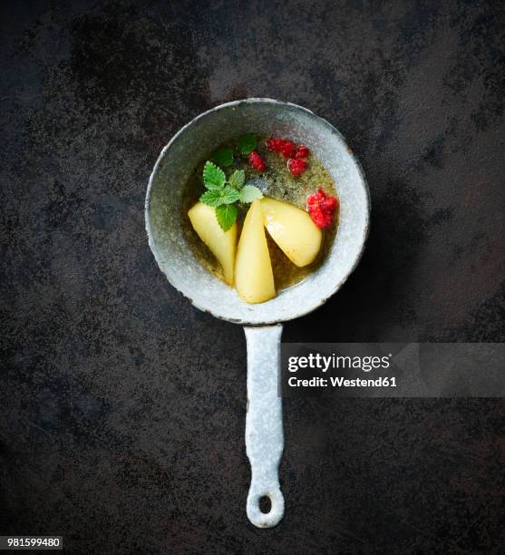 tonka bean pears and raspberries with mint in a saucepan - tonka stock-fotos und bilder