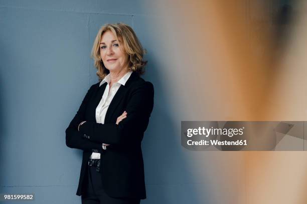 portrait of confident senior businesswoman - woman blue background stock pictures, royalty-free photos & images