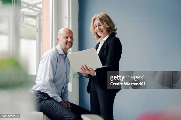businessman and businesswoman working together on laptop - chef stock-fotos und bilder