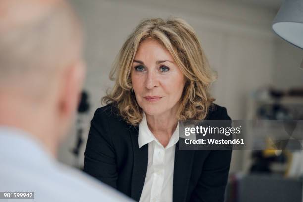 senior businesswoman looking at colleague - business woman talking stock-fotos und bilder