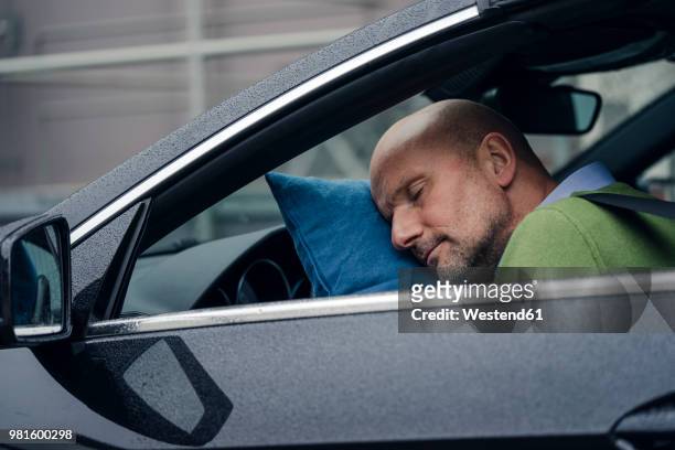 mature man sleeping in car - sleeping in car stockfoto's en -beelden