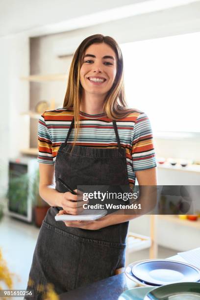 portrait of smiling woman with notebook in kitchen - report fun stock pictures, royalty-free photos & images