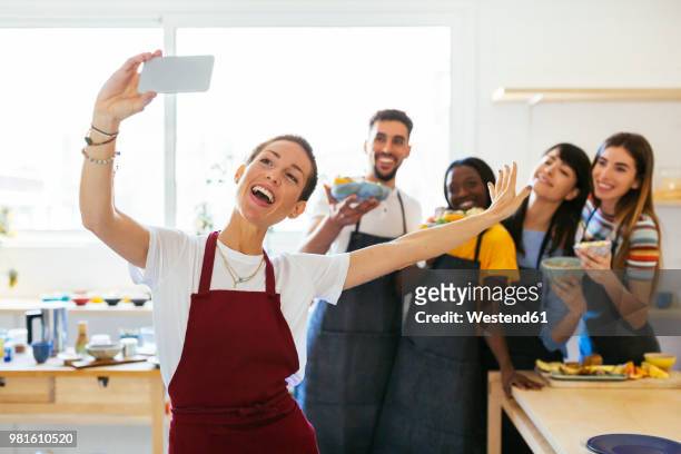playful instructor taking a selfie with friends in a cooking workshop - fun experience stock pictures, royalty-free photos & images
