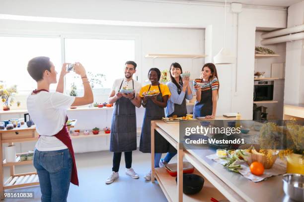 instructor taking a picture of friends in a cooking workshop - accompagnement photos et images de collection