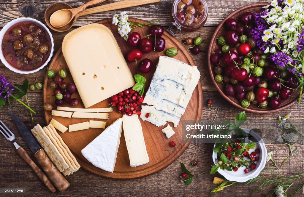 Cheese platter with fresh colorful summer berries