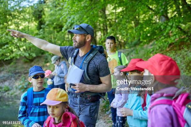 man talking to kids on a field trip in forest - field trip imagens e fotografias de stock