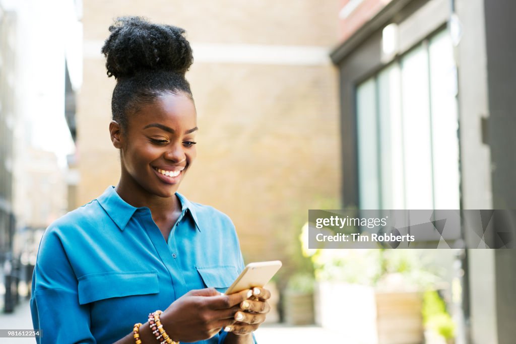 Smiling woman using smartphone