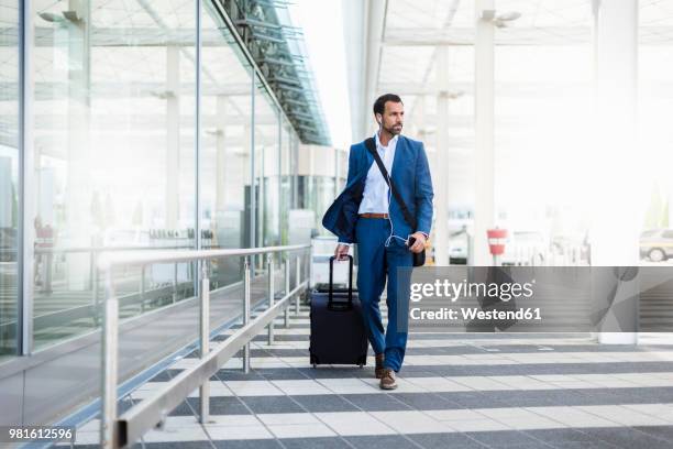 businessman with trolley and smartphone at airport - borsa per laptop foto e immagini stock