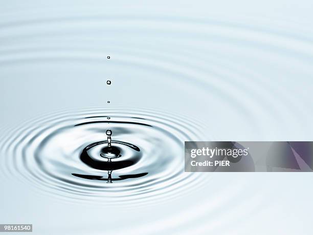 single droplet of water forming rings in pool - water fall stockfoto's en -beelden