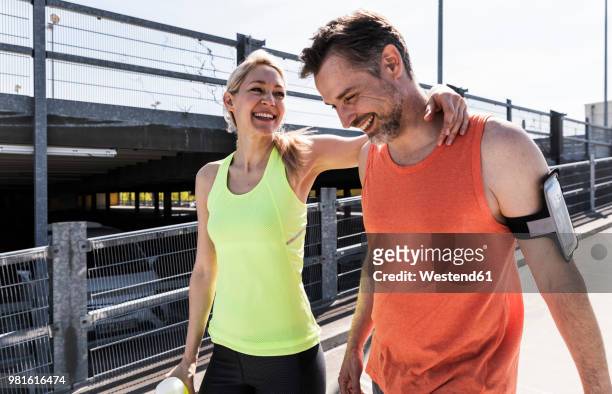 fit couple jogging in the city, having fun, taking a break - fitness couple stockfoto's en -beelden