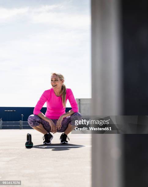 woman training with dumbells, kneeling on ground - fuchsia stock pictures, royalty-free photos & images