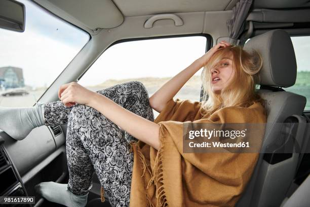 young woman with tousled hair sitting in car - messy car interior stock pictures, royalty-free photos & images