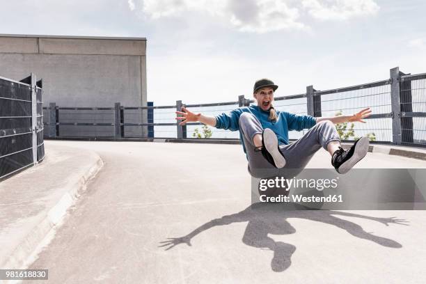 woman sitting on basketball, rolling downhill - rolling stock pictures, royalty-free photos & images