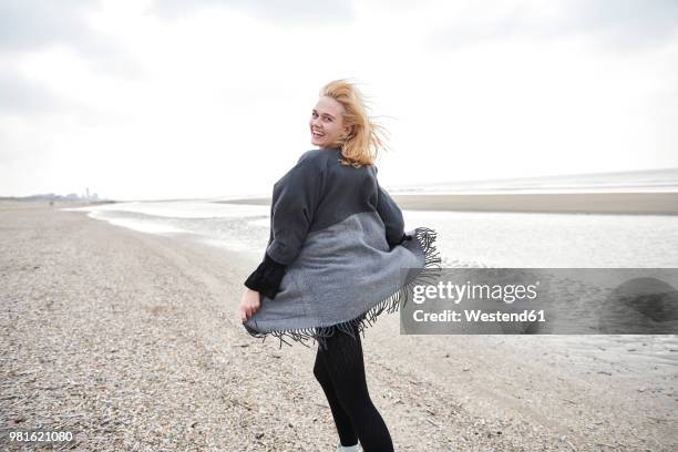 netherlands, portrait of laughing blond young woman on the beach - tide turning stock pictures, royalty-free photos & images