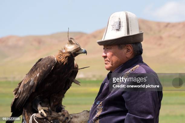 Kyrgyzstan. Issyk-Kul region. Ak Say. Eagle hunter with golden eagle.