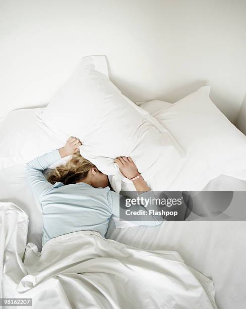 woman having restless nights sleep - slapeloosheid stockfoto's en -beelden