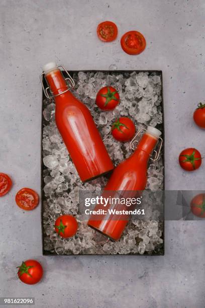 ice-cooled homemade tomato juice in swing top bottles - tomato juice stock pictures, royalty-free photos & images