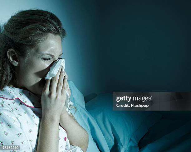 woman blowing her nose in bed - cold stock pictures, royalty-free photos & images