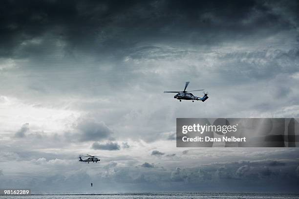 navy helicopters pulling man out of water. - helicóptero - fotografias e filmes do acervo