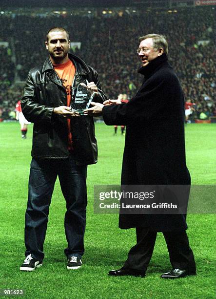 Alex Ferguson the United Manager gives an award to Eric Cantona on the pitch before the match between Manchester United and Charlton Athletic in the...