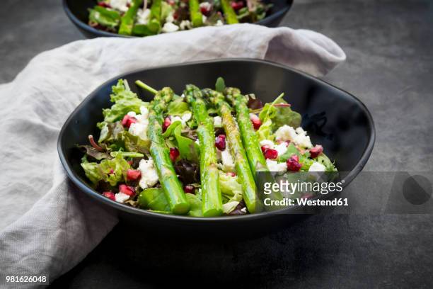 mixed salad with fried green asparagus, feta and pomegranate seeds - asparagus stock pictures, royalty-free photos & images